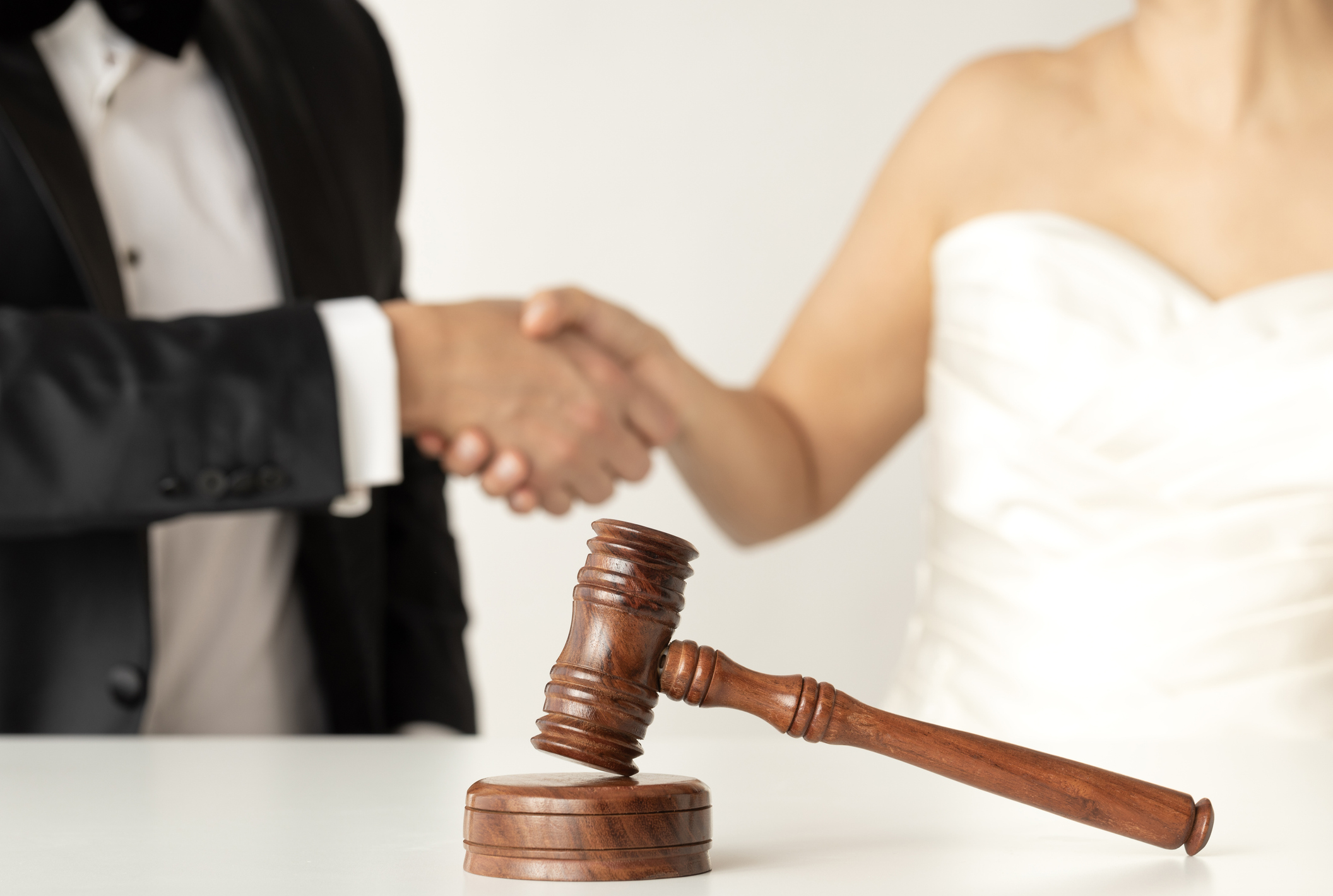 Marriage agreement, gavel, and handshake
