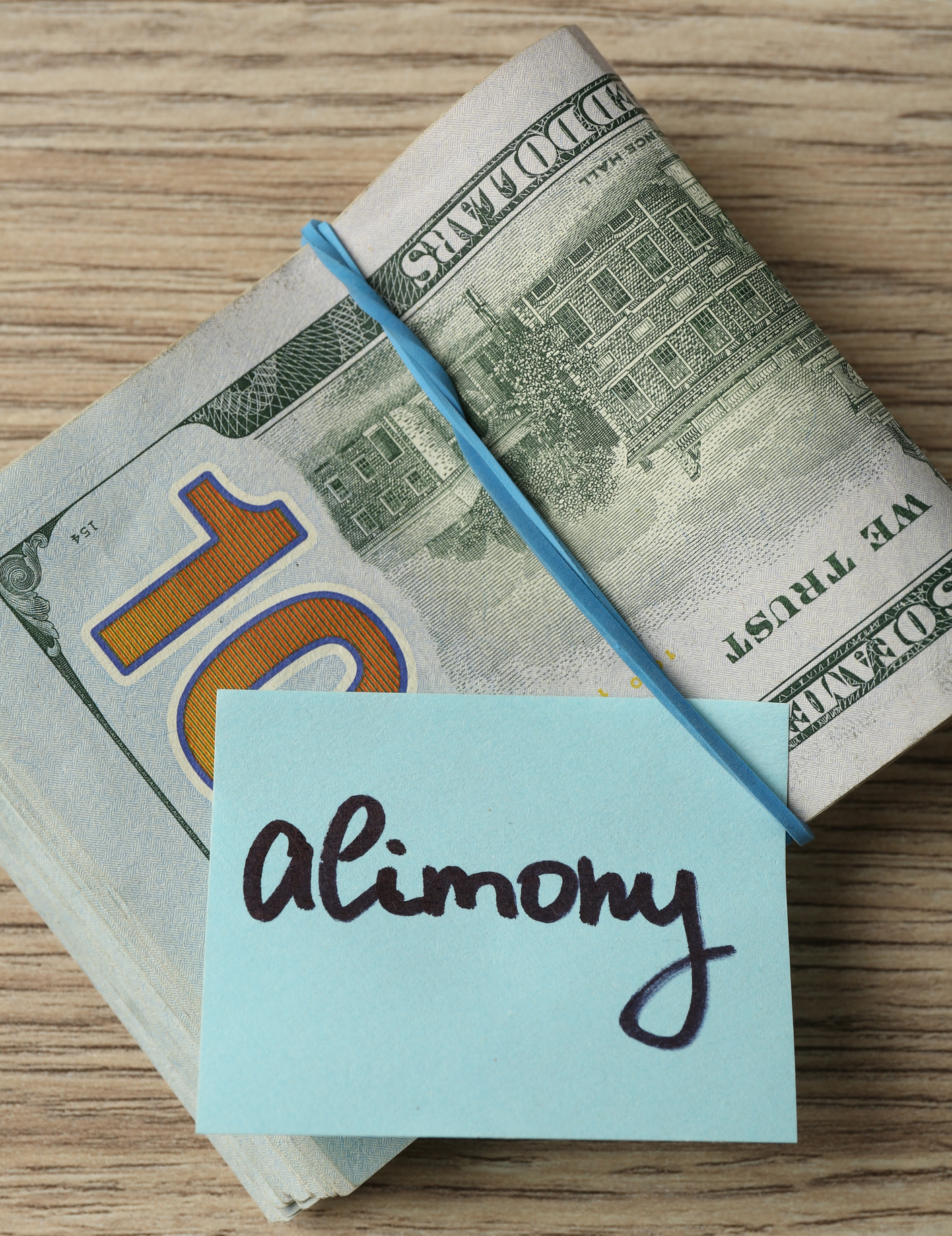Alimony payment with US currency on wood
