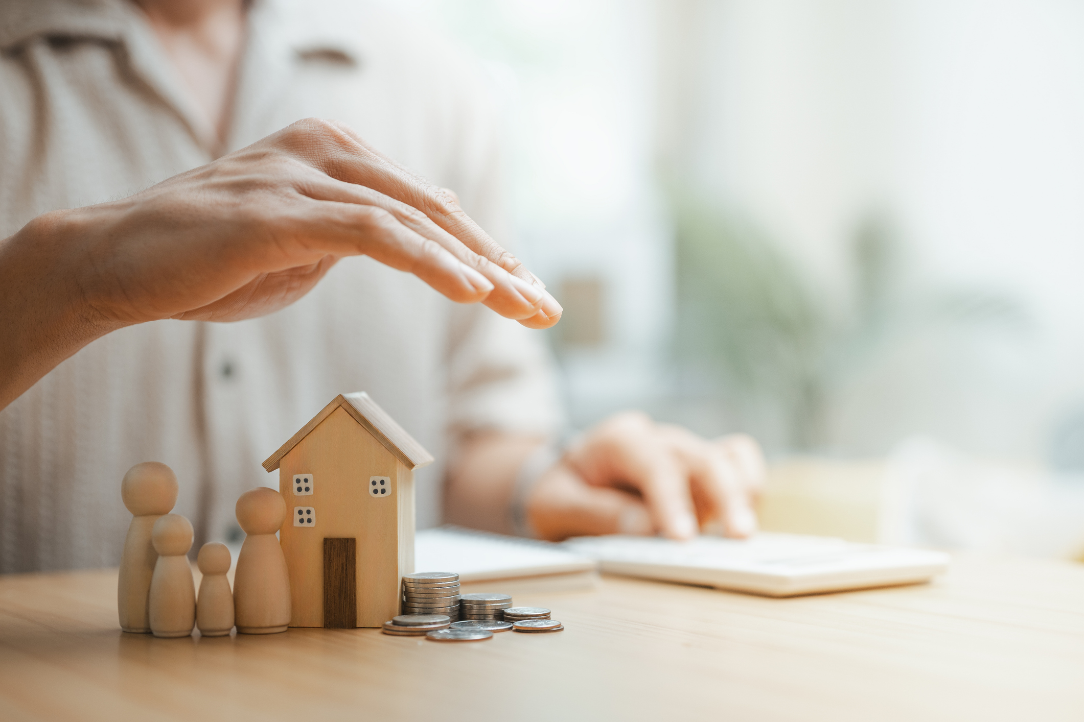 Hand protecting house, family, coins