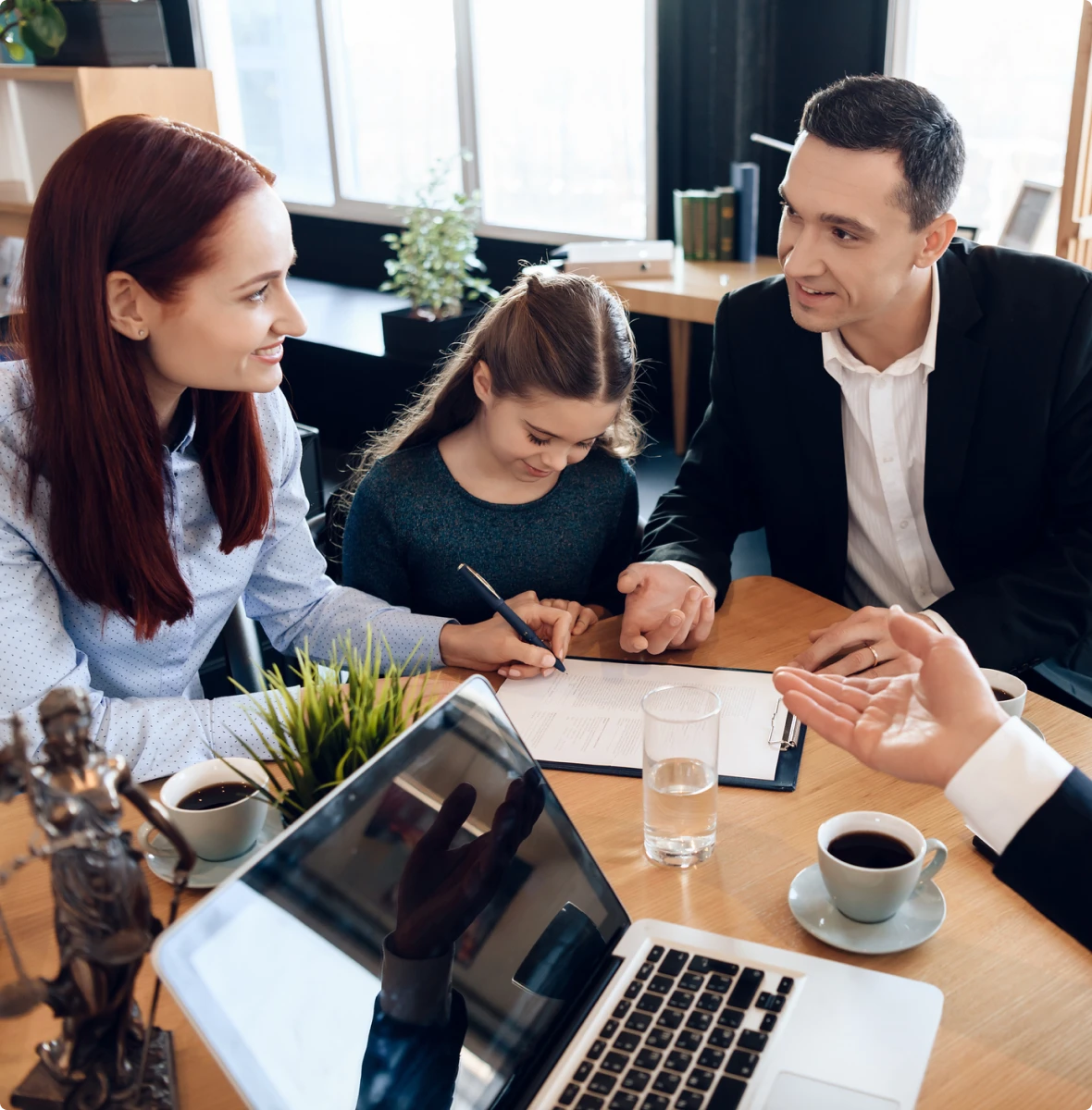 Family signing legal documents with lawyer