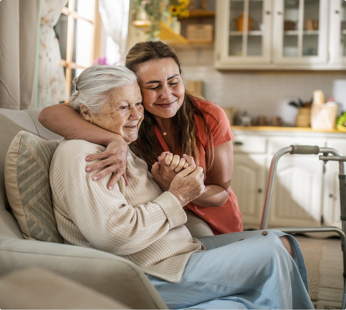 Caregiver hugging elderly woman