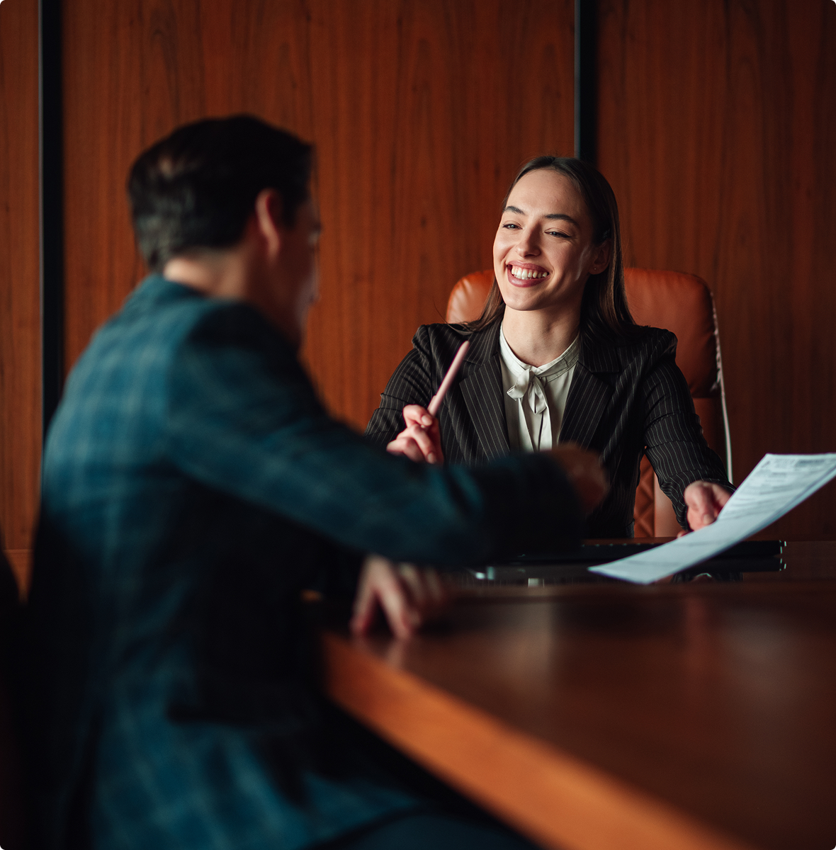 Woman in pinstripe suit holding pen and papers