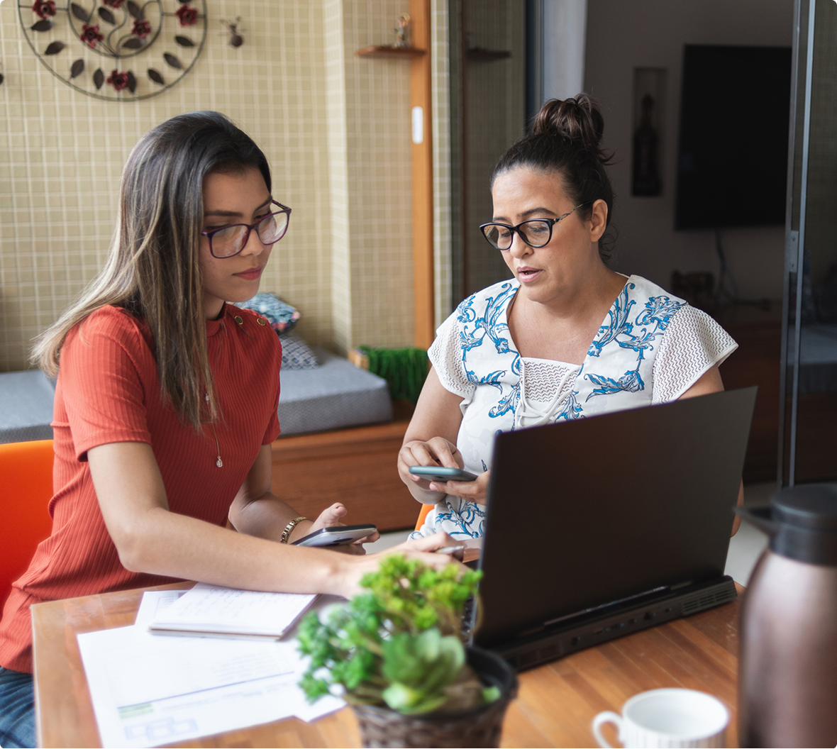 Women collaborating with laptops and phones